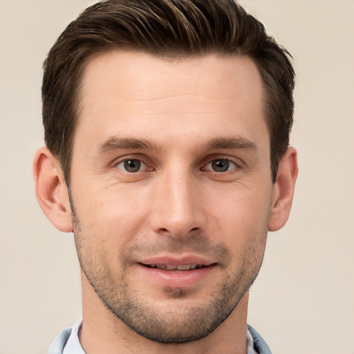 Joyful white young-adult male with short  brown hair and grey eyes