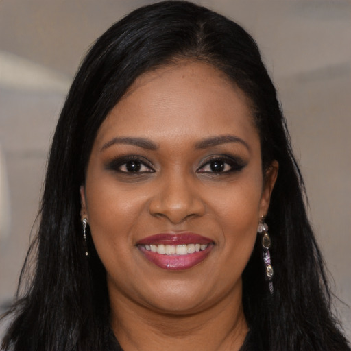 Joyful black young-adult female with long  black hair and brown eyes