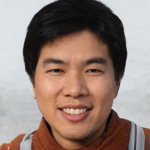 Joyful asian young-adult male with short  black hair and brown eyes