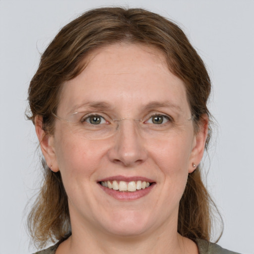 Joyful white adult female with medium  brown hair and grey eyes