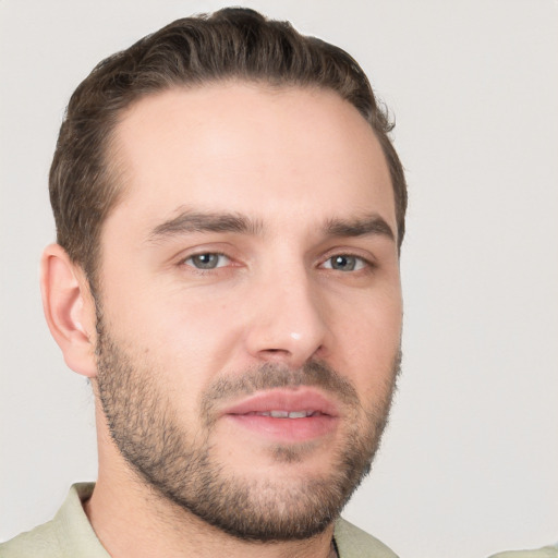 Joyful white young-adult male with short  brown hair and grey eyes