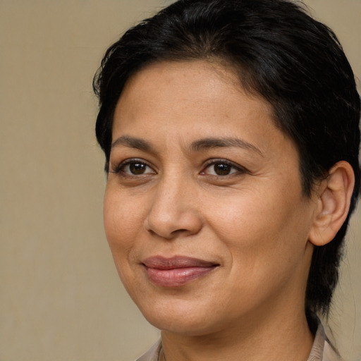 Joyful latino adult female with medium  brown hair and brown eyes