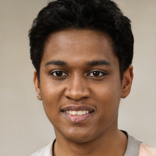 Joyful black young-adult male with short  black hair and brown eyes