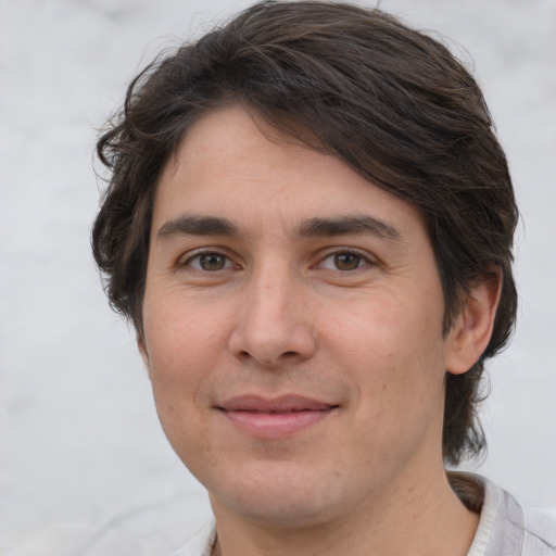 Joyful white young-adult male with medium  brown hair and brown eyes