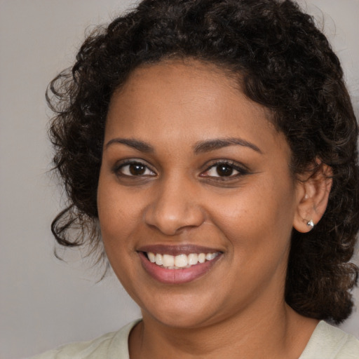 Joyful black young-adult female with medium  brown hair and brown eyes