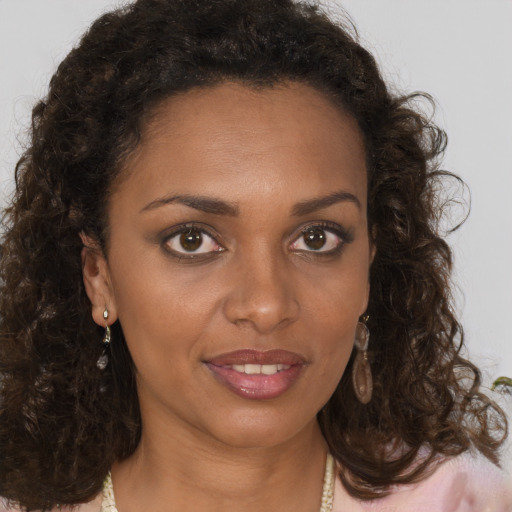 Joyful black young-adult female with medium  brown hair and brown eyes