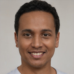 Joyful latino young-adult male with short  black hair and brown eyes