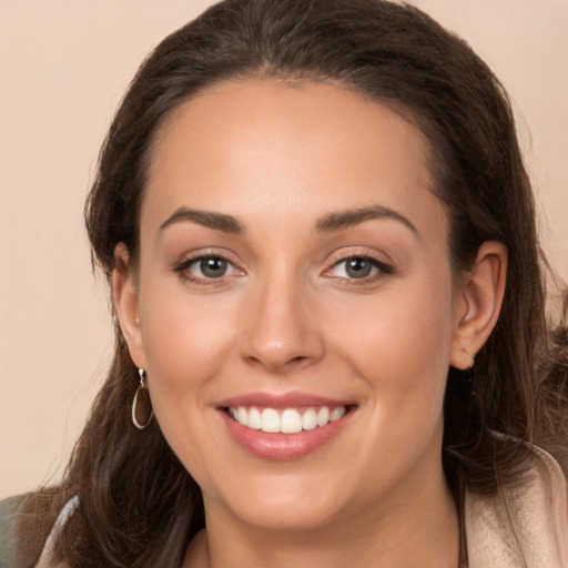 Joyful white young-adult female with long  brown hair and brown eyes