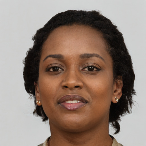 Joyful black young-adult female with short  black hair and brown eyes