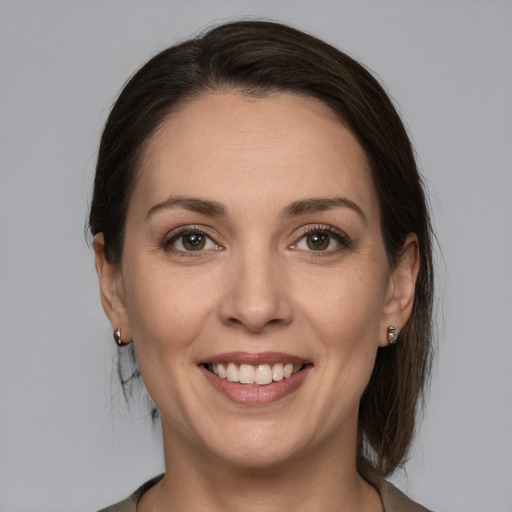 Joyful white young-adult female with medium  brown hair and grey eyes