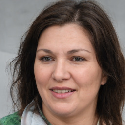 Joyful white adult female with long  brown hair and brown eyes