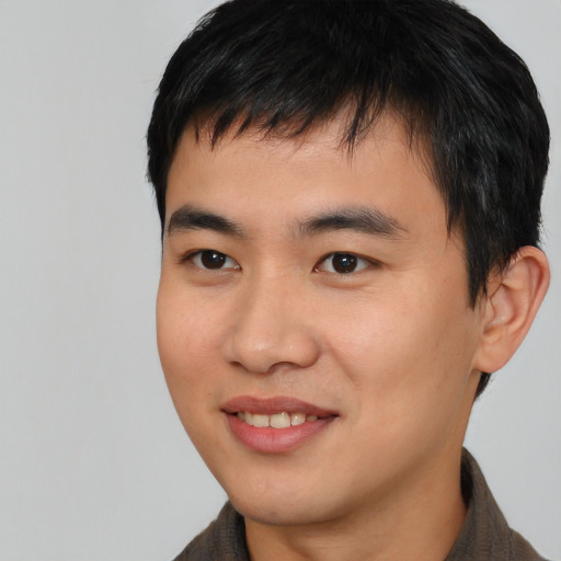 Joyful asian young-adult male with short  black hair and brown eyes