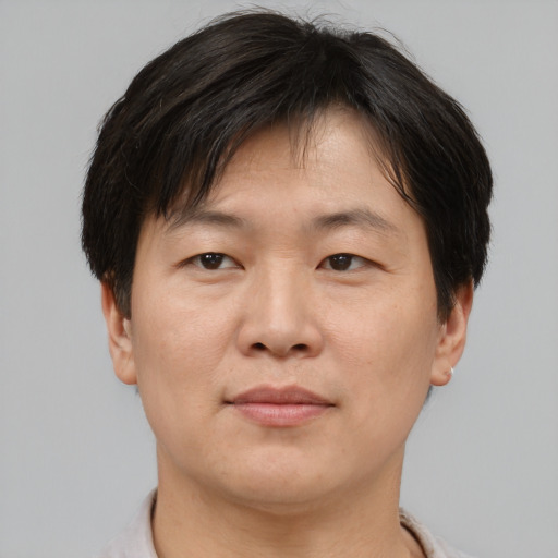 Joyful asian adult male with short  brown hair and brown eyes