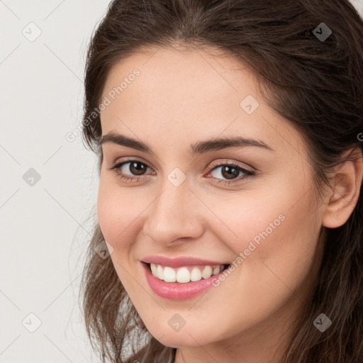 Joyful white young-adult female with long  brown hair and brown eyes