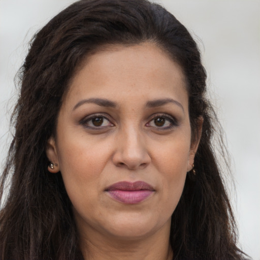 Joyful latino adult female with long  brown hair and brown eyes