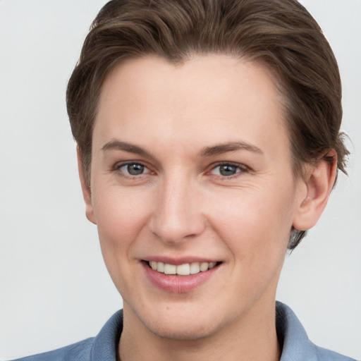 Joyful white young-adult female with short  brown hair and grey eyes