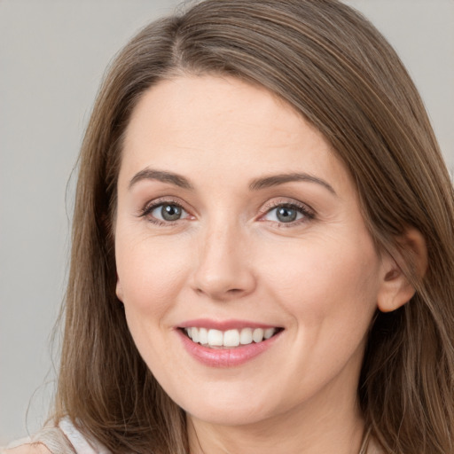 Joyful white young-adult female with long  brown hair and grey eyes