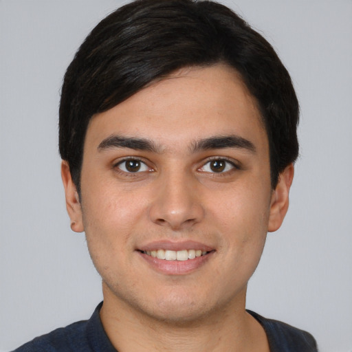 Joyful white young-adult male with short  black hair and brown eyes