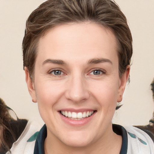 Joyful white young-adult female with medium  brown hair and green eyes