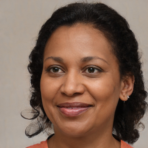 Joyful black adult female with medium  brown hair and brown eyes