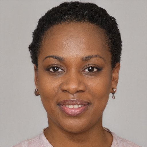 Joyful black young-adult female with short  black hair and brown eyes