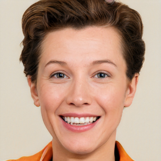 Joyful white young-adult female with short  brown hair and grey eyes