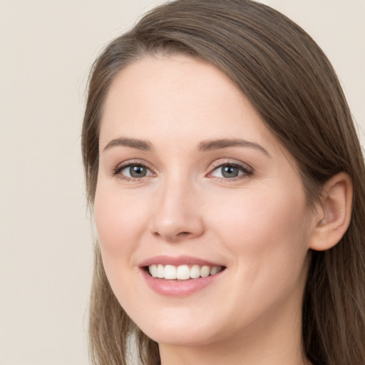 Joyful white young-adult female with long  brown hair and grey eyes