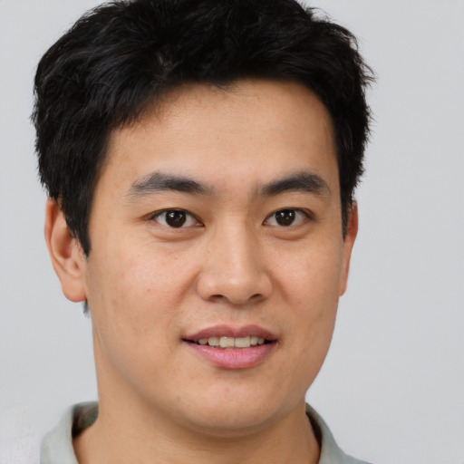 Joyful asian young-adult male with short  brown hair and brown eyes