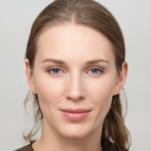 Joyful white young-adult female with medium  brown hair and grey eyes