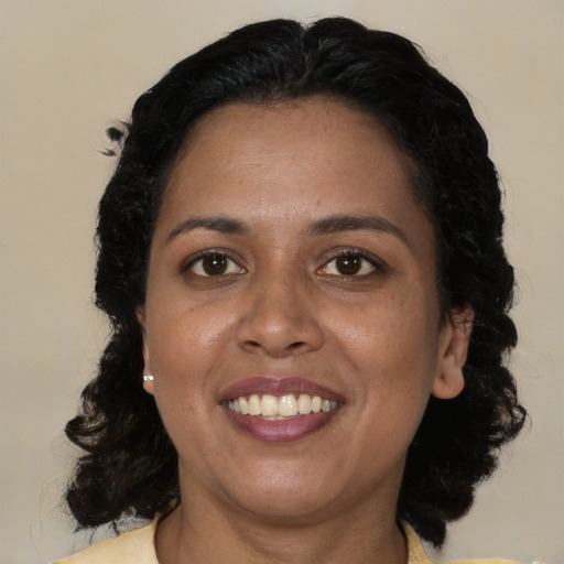 Joyful black adult female with medium  black hair and brown eyes
