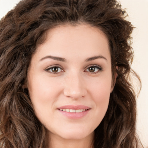 Joyful white young-adult female with long  brown hair and brown eyes