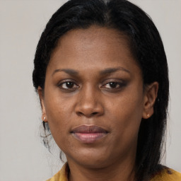 Joyful black young-adult female with long  brown hair and brown eyes