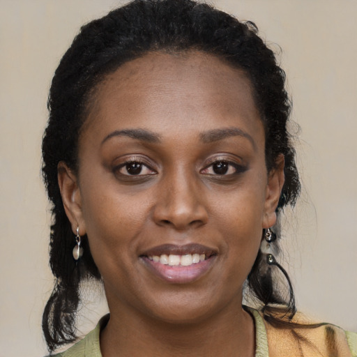 Joyful black young-adult female with long  brown hair and brown eyes