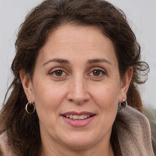 Joyful white adult female with long  brown hair and brown eyes