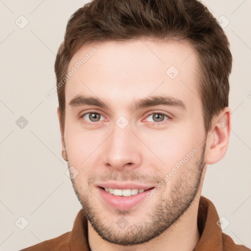 Joyful white young-adult male with short  brown hair and grey eyes