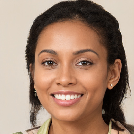 Joyful latino young-adult female with long  brown hair and brown eyes