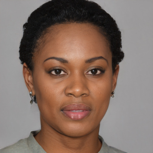 Joyful black young-adult female with short  black hair and brown eyes