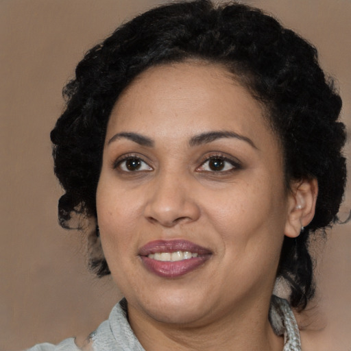 Joyful black adult female with medium  black hair and brown eyes