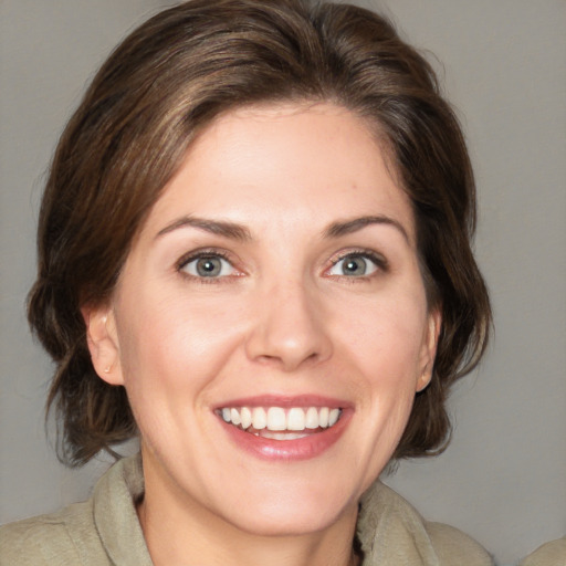 Joyful white young-adult female with medium  brown hair and blue eyes