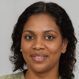 Joyful black adult female with medium  brown hair and brown eyes