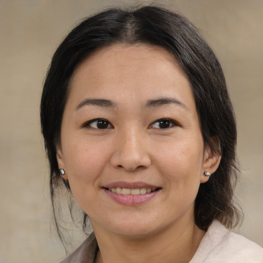 Joyful asian adult female with medium  brown hair and brown eyes