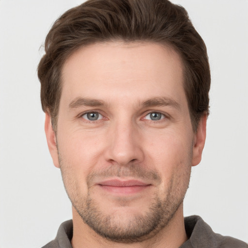 Joyful white young-adult male with short  brown hair and grey eyes