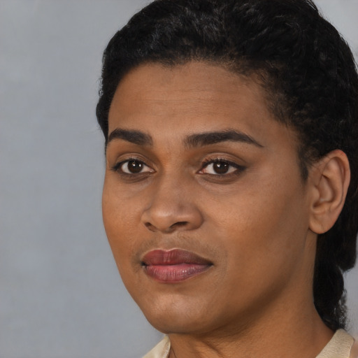 Joyful black young-adult female with short  black hair and brown eyes