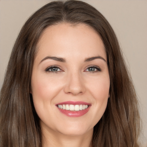 Joyful white young-adult female with long  brown hair and brown eyes