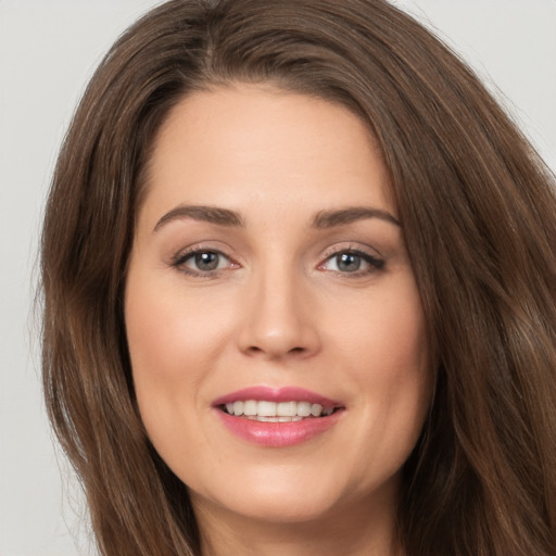 Joyful white young-adult female with long  brown hair and brown eyes