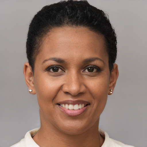 Joyful black young-adult female with short  black hair and brown eyes