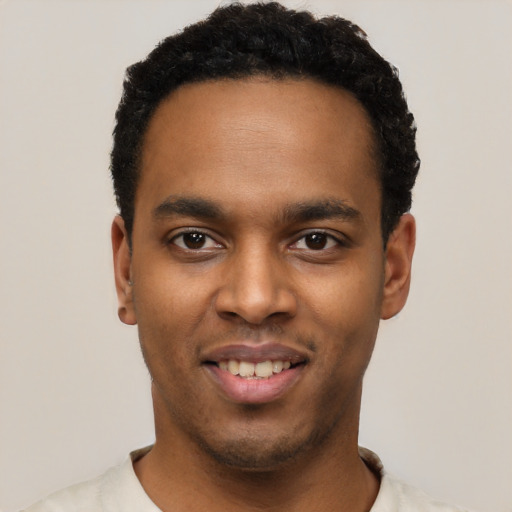 Joyful black young-adult male with short  black hair and brown eyes
