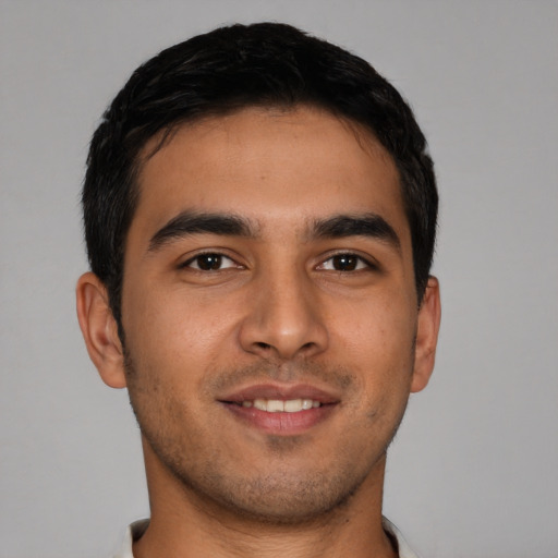 Joyful latino young-adult male with short  brown hair and brown eyes