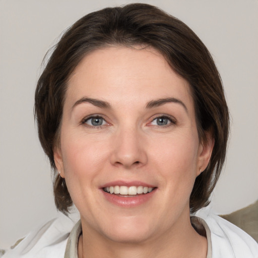 Joyful white adult female with medium  brown hair and grey eyes