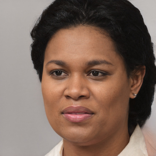 Joyful black adult female with short  black hair and brown eyes